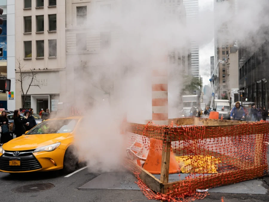 Ein gelbes Taxi fährt an aufsteigendem Strassendampf in Manhattan vorbei