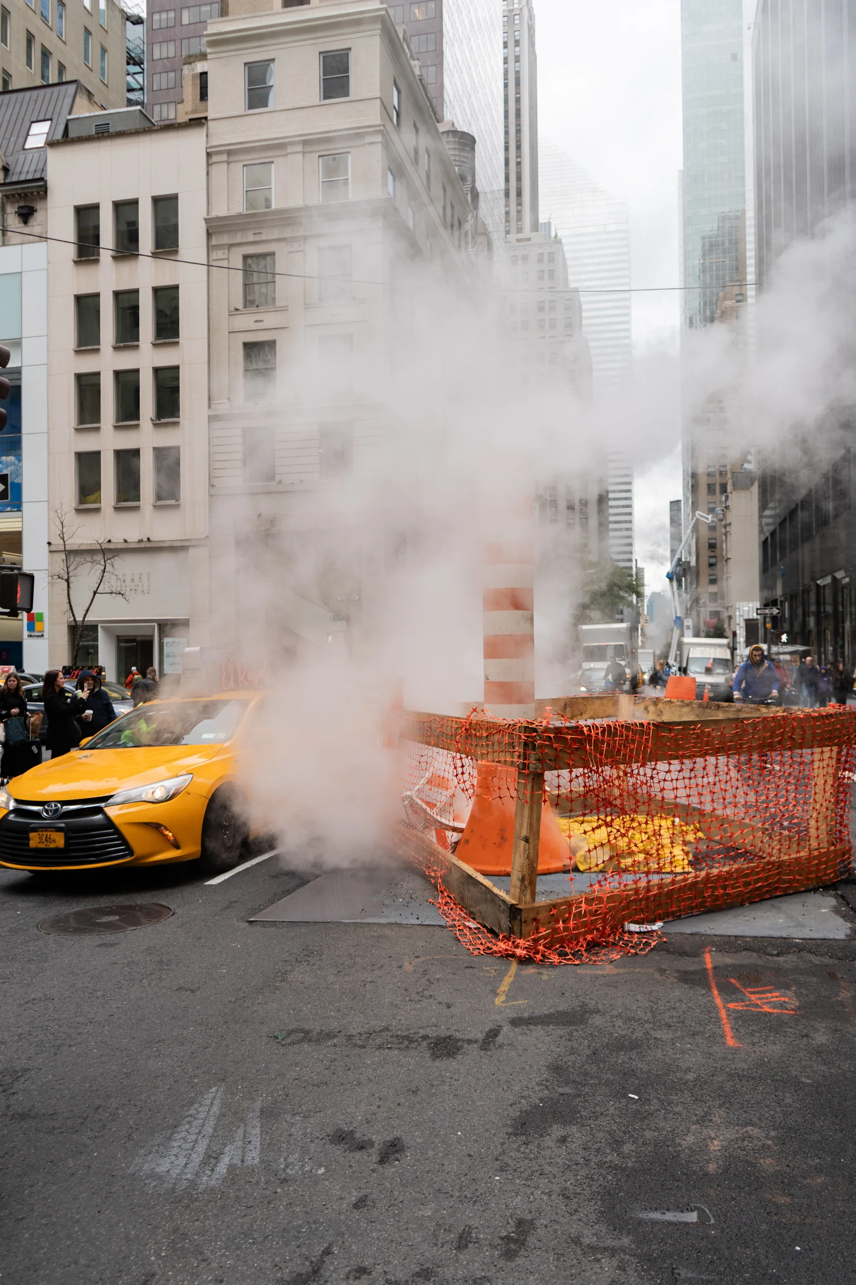Ein gelbes Taxi fährt an aufsteigendem Strassendampf in Manhattan vorbei