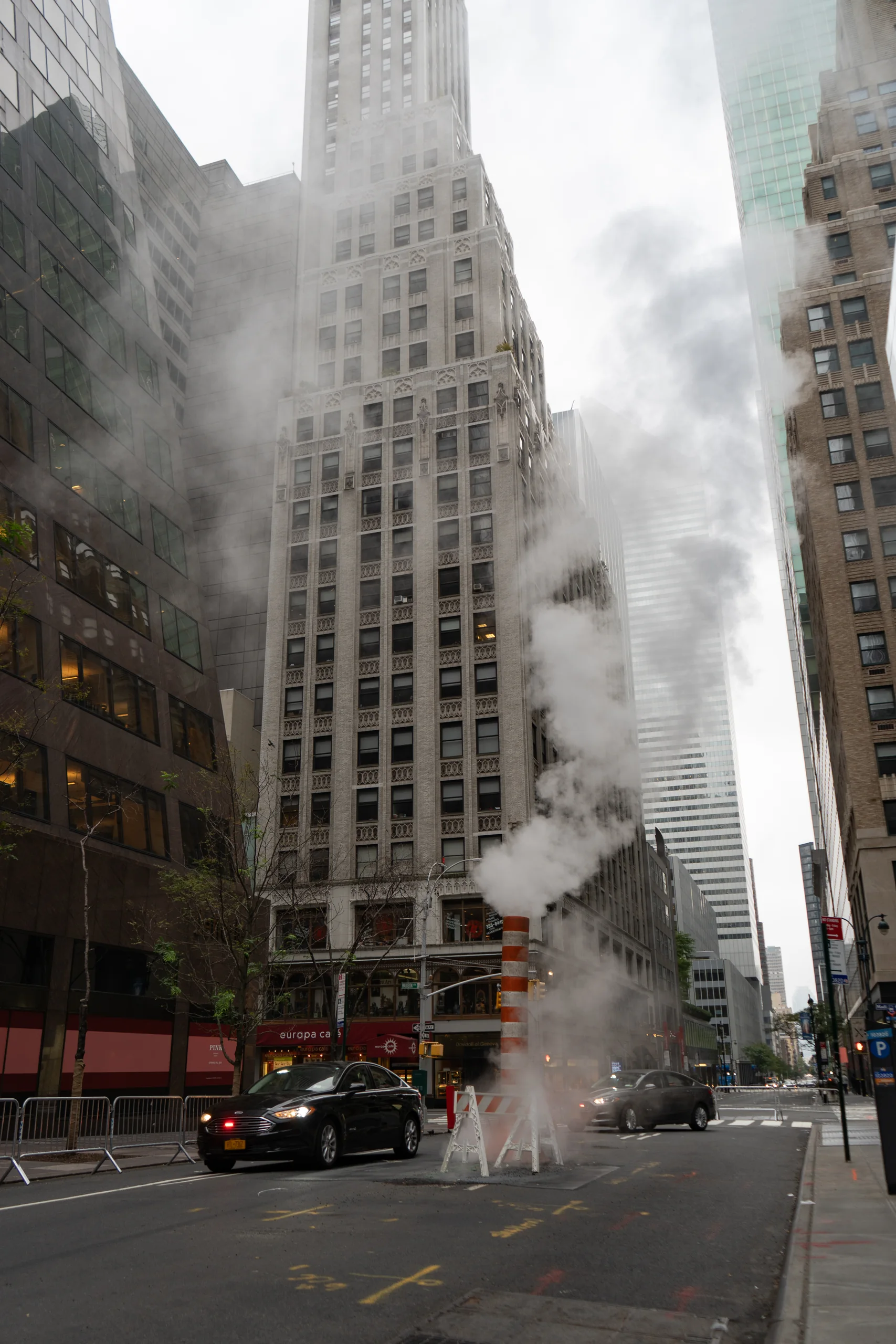 Dampf steigt zwischen den Hochhäusern einer Strasse in Manhattan auf